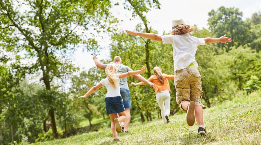 Family exploring nature during the summer months referencing a blog about a Montessori School digital detox for summer to keep balance in kids days.